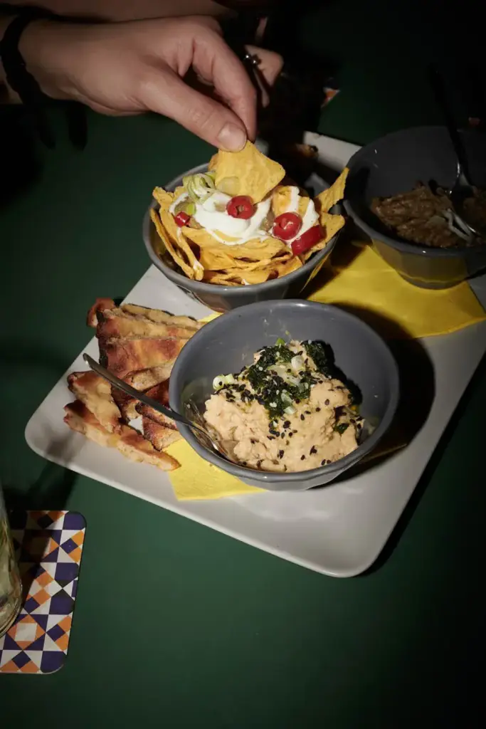 People eating at aperitivo nachos pita and hummus